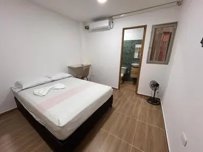 a bedroom with a white bed and a mirror at Apartamento Villa Mary C-202 in Coveñas