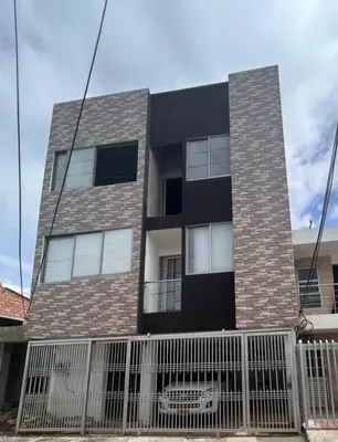 a tall brick building with a fence in front of it at Apartamento Villa Mary C-202 in Coveñas