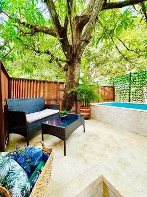 a patio with a tree and a couch and a table at Glamping Arena in El Porvenir