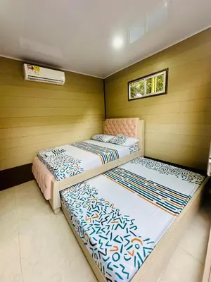 two beds in a room with wooden walls at Glamping Arena in El Porvenir
