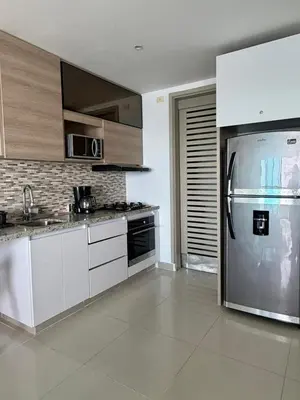 a kitchen with white cabinets and a stainless steel refrigerator at Palmeto Beach 04 - 1 alcoba in Cartagena de Indias