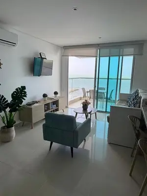 a living room with a green couch and a table at Palmeto Beach 04 - 1 alcoba in Cartagena de Indias