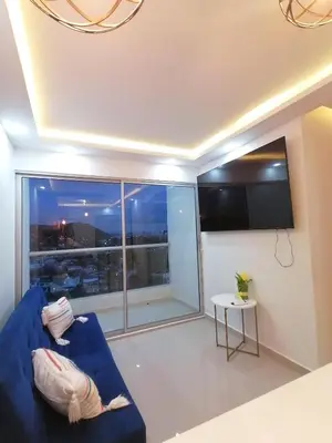 a living room with a blue couch and a large window at Apartamento Rosedale in Cartagena de Indias