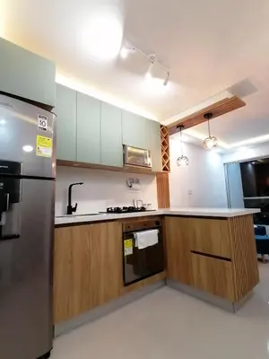 a kitchen with wooden cabinets and a stainless steel refrigerator at Apartamento Rosedale in Cartagena de Indias