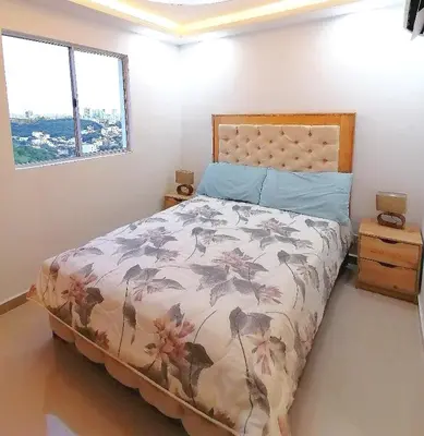 a bedroom with a bed and two windows at Apartamento Rosedale in Cartagena de Indias