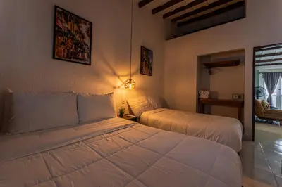 a bedroom with two beds in a room at Amplio apartamento familiar de 2 habitaciones dentro de la Ciudad Amurallada - AC, Wifi rapido y Agua caliente in Cartagena de Indias