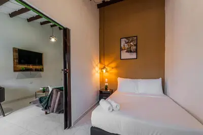 a bedroom with a white bed in a room at Amplio apartamento familiar de 2 habitaciones dentro de la Ciudad Amurallada - AC, Wifi rapido y Agua caliente in Cartagena de Indias