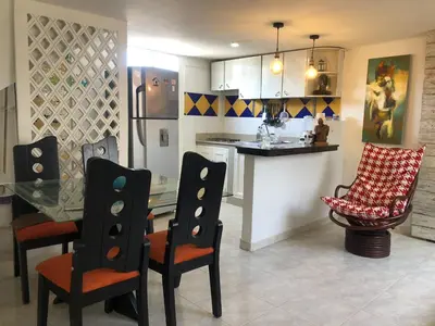 a kitchen with a table and chairs and a counter at El taller del artista I in Cartagena de Indias