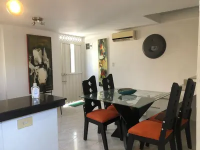 a dining room with a glass table and chairs at El taller del artista I in Cartagena de Indias