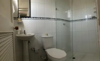 a white bathroom with a toilet and a sink at El taller del artista I in Cartagena de Indias