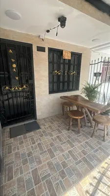 a patio with a wooden table and benches on a tile floor at Casa Étoile ideal location Ctg in Cartagena de Indias