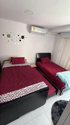 two beds in a small room with red sheets at Casa Étoile ideal location Ctg in Cartagena de Indias