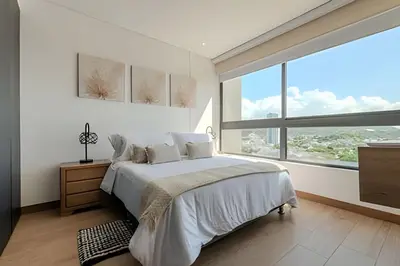 a white bedroom with a bed and a large window at Lujoso y Nuevo Cerca al Centro/ Piscina Panorámica in Cartagena de Indias