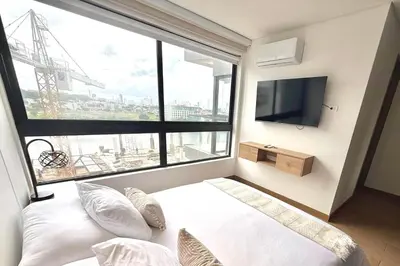 a bedroom with a bed and a large window at Lujoso y Nuevo Cerca al Centro/ Piscina Panorámica in Cartagena de Indias