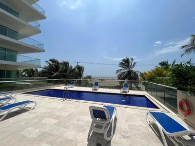 a swimming pool with two lawn chairs and a swimming pool at Espectacular apto frente al Mar! in Cartagena de Indias