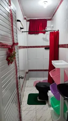 a bathroom with a shower with two toilets and a red curtain at Apartamento #1 in Puerto Colombia