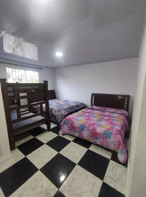 a bedroom with two beds and a checkered floor at Apartamento #1 in Puerto Colombia