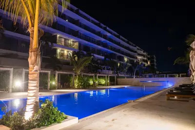 a swimming pool in front of a building at night at Loft con salida al mar en Cartagena in Cartagena de Indias