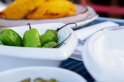a white bowl of green peppers on a table at Lujosa Casa 5Hab Jacuzzi & Piscina in Cartagena de Indias