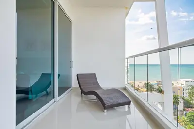 a balcony with a chair and a view of the ocean at Beach 2-bedroom apartment in Cartagena de Indias