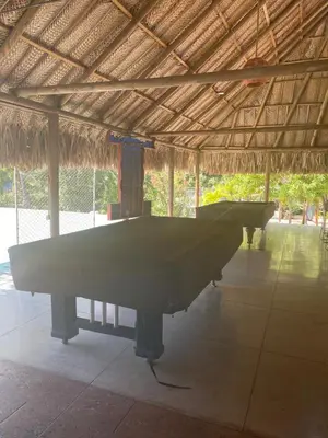 a large pool table in a straw roofed building at Playa Los alcatraces in Santa Marta