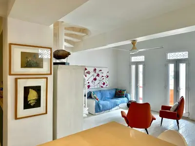 a living room with a blue couch and red chairs at by Calamari Homes - El Porvenir 401 walled city in Cartagena de Indias