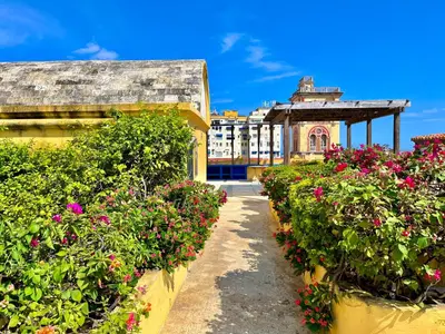 a garden with flowers inront of a building at by Calamari Homes - El Porvenir 401 walled city in Cartagena de Indias