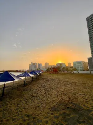 a row of blue umbrellas on a beach with a city at Murano centro 1 - 25 Floor byIMZ in Cartagena de Indias