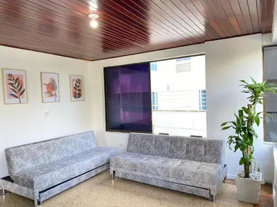a living room with two couches and a large tv at Acogedor Apartamento cerca al Mar in Cartagena de Indias