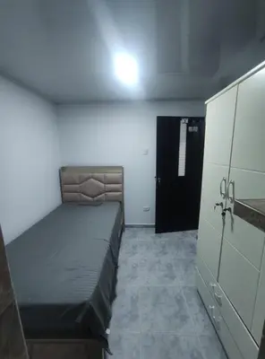 a small bedroom with a bed and a black door at Apartamento #3 in Puerto Colombia