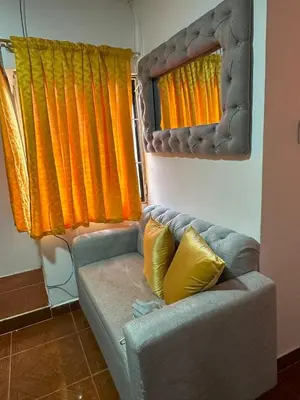a couch in a room with orange and yellow curtains at Apartamento #3 in Puerto Colombia