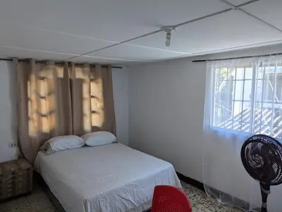 a bedroom with a bed and a window at BAQ central point in Barranquilla