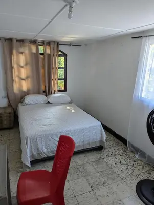 a bedroom with a bed and a red chair at BAQ central point in Barranquilla