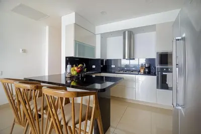a kitchen with a black counter and a refrigerator at Luxury apt sea front AC Wifi pool at cartagena in Cartagena de Indias
