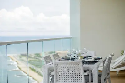 a dining table with chairs and a view of the ocean at Luxury apt sea front AC Wifi pool at cartagena in Cartagena de Indias