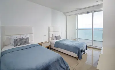 a bedroom with two beds and a view of the ocean at Luxury apt sea front AC Wifi pool at cartagena in Cartagena de Indias