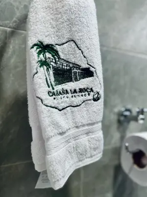 a towel hanging in a bathroom next to a toilet at Cabaña La Roca in San Antero