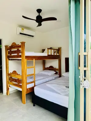 two bunk beds in a room with a ceiling fan at Cabaña La Roca in San Antero
