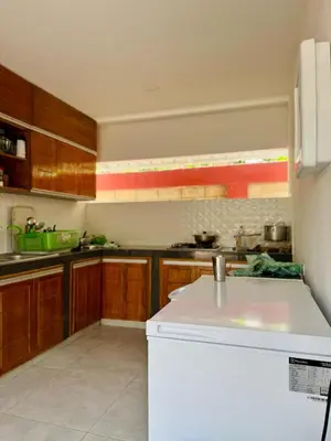 a kitchen with wooden cabinets and a white refrigerator at Cabaña La Roca in San Antero