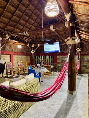 a hammock in a room with a table and chairs at Cabaña La Roca in San Antero
