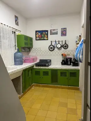 a kitchen with green cabinets and a stove at Cabaña Mery frente al mar in San Antero