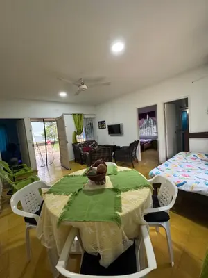 a room with a table and chairs and a bedroom at Cabaña Mery frente al mar in San Antero