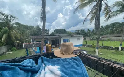 a hat and sunglasses sitting on a fence in front of a house at Cabaña Mery frente al mar in San Antero