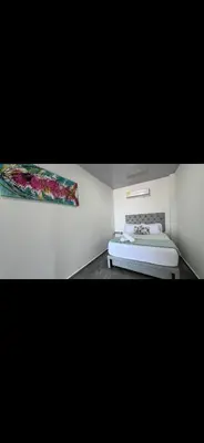 a bedroom with a bed and a painting on the wall at casa kite school in Cartagena de Indias
