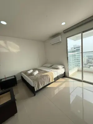 a bedroom with a bed and a large window at Apartamento Magnoloft Bocagrande in Cartagena de Indias