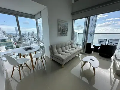 a living room with a couch and a table and chairs at Apartamento Magnoloft Bocagrande in Cartagena de Indias