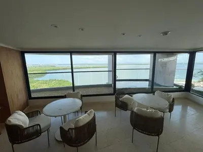 a room with tables and chairs in a building with windows at Amazing Bay View Apartment in Cartagena! in Cartagena de Indias