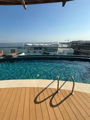 a swimming pool with a chair in the water at Amazing Bay View Apartment in Cartagena! in Cartagena de Indias