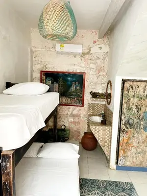 a room with two bunk beds and a bathroom at Pachamama Hostel in Cartagena de Indias