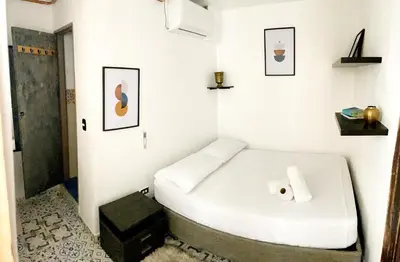 a small white room with a bed with a roll of toilet paper at Pachamama Hostel in Cartagena de Indias